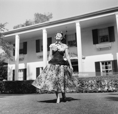 Donna Reed poses at home in glamorous dress.jpg