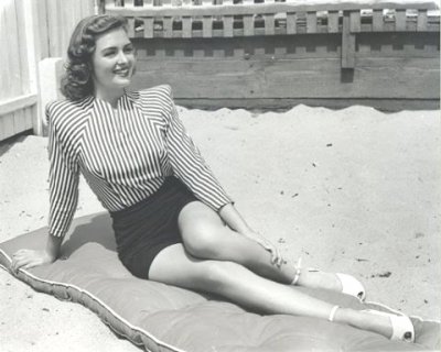 Donna Reed lounging on lounge mattress on sand AOL.jpg