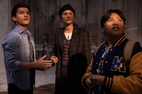 Peter (Tom Holland), MJ (Zendaya), and Ned (Jacob Batalon) are standing in a strange room with antique furniture.
