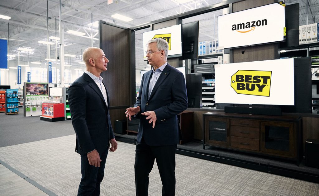 Amazon CEO Jeff Bezos (left) and Best Buy CEO Hubert Joly (right)