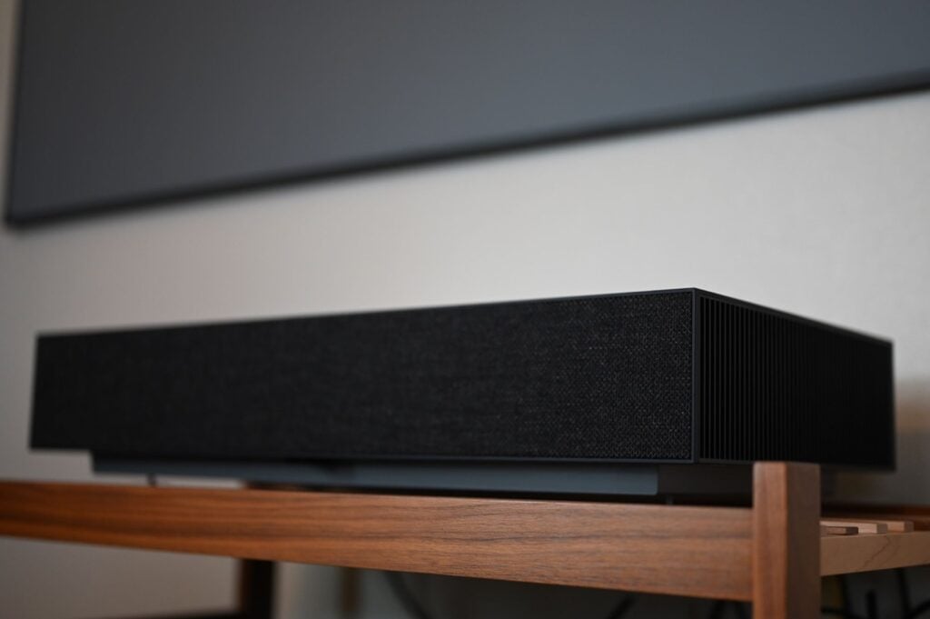 LG CineBeam HU915QB sitting under a screen.